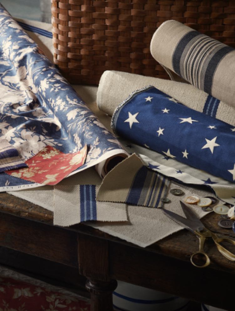 White and blue wallcoverings on a table with scissors.